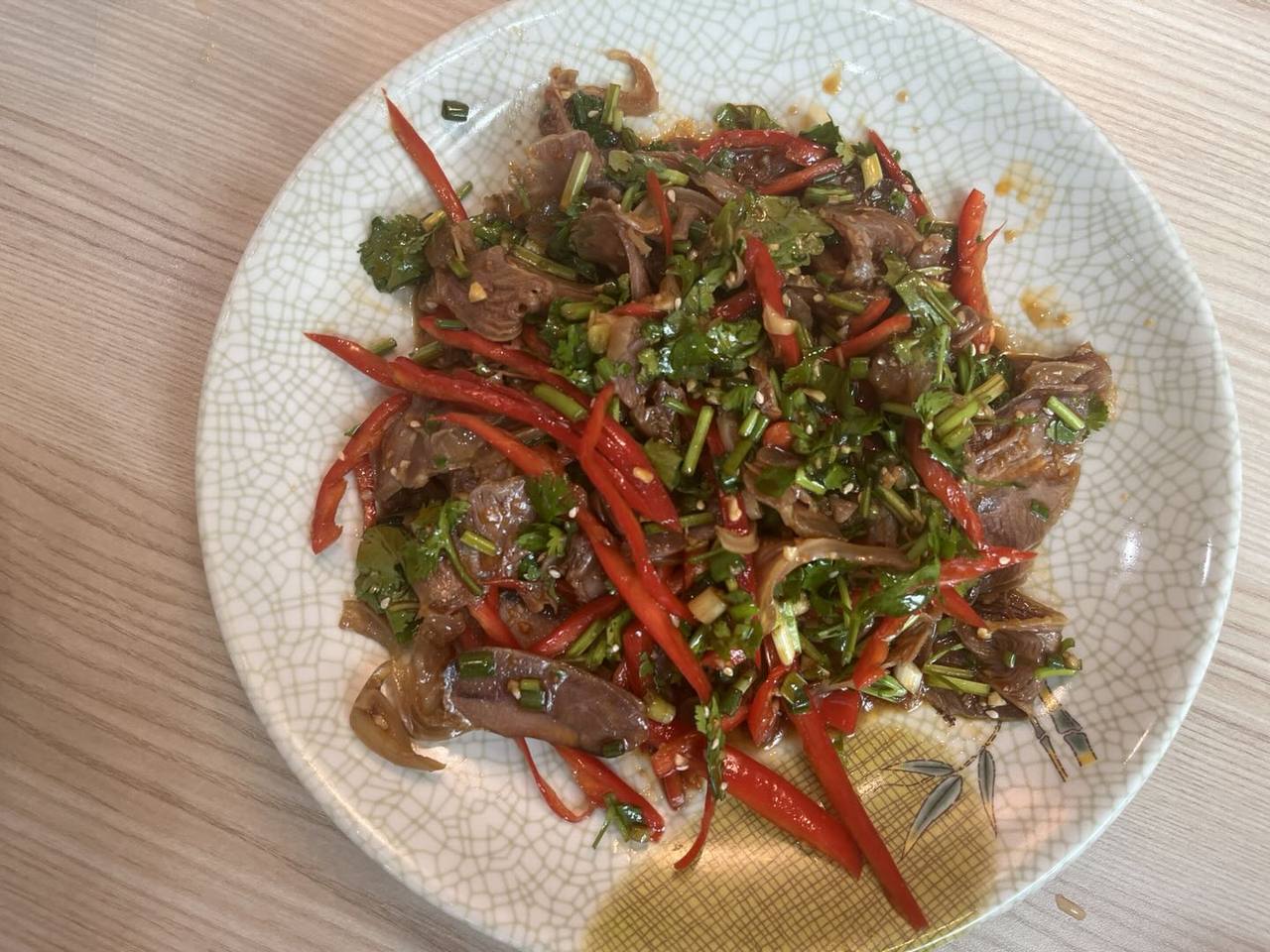 红辣椒和香菜点缀的凉拌羊肉