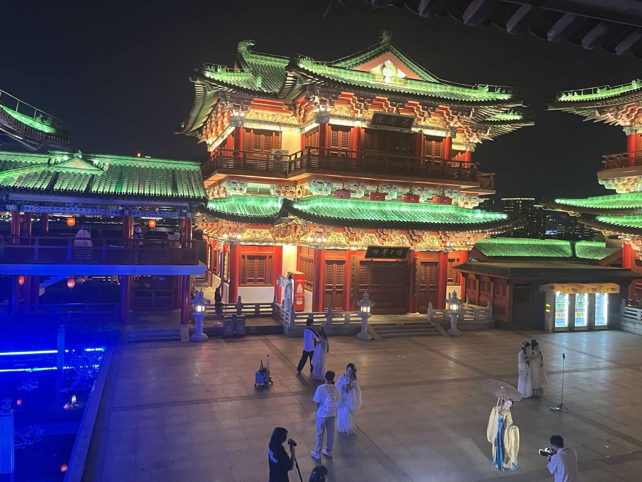 夜间灯光下的滕王阁建筑群与广场上的汉服游客